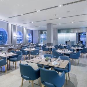 a dining room with tables and blue chairs at H Luxury Apartment at Surfers Paradise High floor in Gold Coast