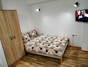 a bedroom with a bed and a tv on a wall at Mavrovo Forest Apartments in Mavrovo