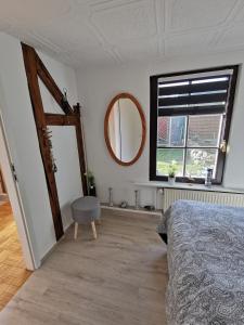 a bedroom with a bed and a mirror and a window at Bungalow bei Warnemünde in Elmenhorst