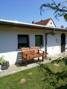 a wooden bench sitting outside of a house at Bungalow bei Warnemünde in Elmenhorst