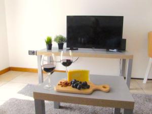 einen Tisch mit zwei Gläsern Wein und ein Tablett mit Trauben in der Unterkunft Vicenza City Apartments 2 in Vicenza