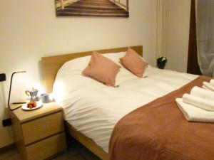 a bed with white sheets and two pillows on it at Vicenza City Apartments 2 in Vicenza