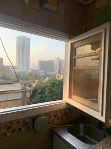 a window in a kitchen with a view of a city at Beautiful and cozy duplex in the heart of Cairo in Cairo