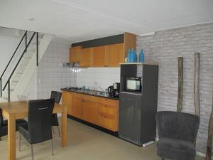een keuken met een koelkast en een tafel met stoelen bij Vakantiehuisje gelegen op een kattensprong van Veerse Meer en Noordzee! in Kamperland