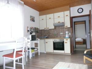 a kitchen with white cabinets and a table and chairs at Apartment Ahoi in Büsum