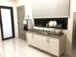 uma cozinha com um lavatório e um micro-ondas em SS Ipoh Comfort Homestay - For Families and Groups em Ipoh