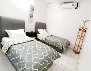 duas camas sentadas uma ao lado da outra num quarto em SS Ipoh Comfort Homestay - For Families and Groups em Ipoh