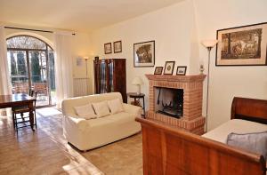 a living room with a fireplace and a chair at Agriturismo I Gergoni in Monteleone dʼOrvieto