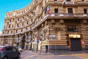 ein Gebäude mit einem davor geparkten Auto in der Unterkunft Quatrum Napoli - B&B in Neapel
