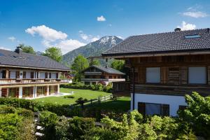 - une vue sur une maison avec des montagnes en arrière-plan dans l'établissement Bodenschneid Suiten Ringbergblick, à Rottach-Egern