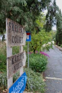 Um sinal que diz "Skates Court" e "Kate Village" em skeleas 10 em Pissouri
