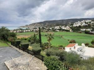 a house with a fence in a green field at skeleas 10 in Pissouri