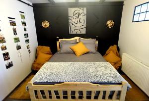a small bedroom with a bed with yellow pillows at Night Lotus in Hunedoara