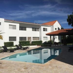 璜多里奧的住宿－Los Corozos apartment M2, Guavaberry Golf & Country Club，建筑前的一座带游泳池的建筑