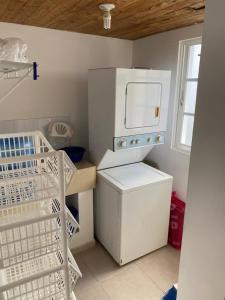 a small kitchen with a refrigerator and a dishwasher at Los Corozos apartment M2, Guavaberry Golf & Country Club in Juan Dolio
