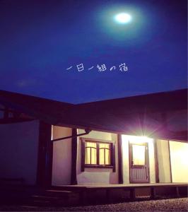 un bâtiment la nuit avec la lune dans le ciel dans l'établissement 海の近くの宿 アトリエ モダン, à Sakaiminato