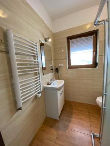 a bathroom with a sink and a toilet and a window at Dom Nad Brennica in Brenna