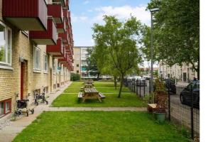 een park met picknicktafels in het gras naast gebouwen bij 300 m to Metro: 5 min airport/12 min Copenhagen C in Kopenhagen