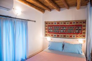 una camera da letto con un letto con arazzo appeso al muro di Grandmother's house a Psinthos