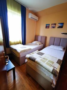 a room with two beds and a window with at Explorer Podgorica in Podgorica