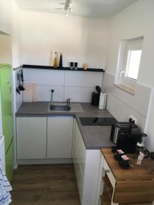 eine Küche mit einer Spüle und einer Arbeitsplatte in der Unterkunft Liebevoll renoviertes Apartment mit Panoramablick in Friedrichshafen