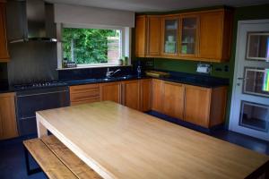 a kitchen with wooden cabinets and a wooden table at Doeselie deux in Ronse
