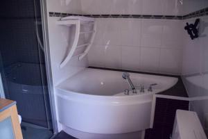 Una bañera blanca en un baño con ducha. en Doeselie deux, en Ronse
