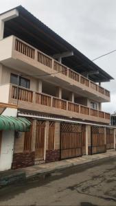 a building with wooden doors and a balcony at CRUCITALIA suite x 4 in Crucita