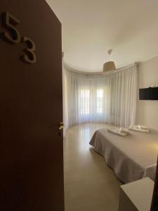 ミラノにあるホテル ドゥエ ジャルディーニのベッドルーム(白いベッド1台、窓付)