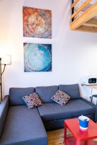 un sofá azul en una sala de estar con una mesa roja en Apartamentos Las Secuoyas, en Ayuela