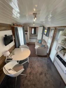 een woonkamer met een tafel en stoelen in een trailer bij B&B Hetvrijdagsgevoel in Sneek