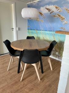 Surfers Paradise Apartments في فيد ساندي: طاولة طعام مع كراسي و لوحة للمحيط
