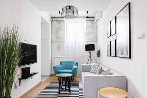 a living room with a blue chair and a couch at HostGost Selected Suites - Molerova 9 in Belgrade