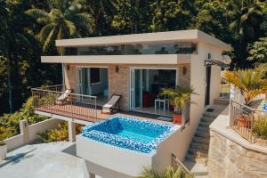 une villa avec une piscine en face d'une maison dans l'établissement Moulin Kann Villas, à Mahé