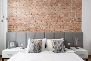a bedroom with a brick wall and a bed at HostGost Selected Suites - Molerova 9 in Belgrade