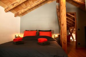 1 dormitorio con 1 cama grande con almohadas rojas en La Pieuca en Les Contamines-Montjoie