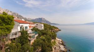 a building on a cliff next to the water at Casa Del Sole in Gradac