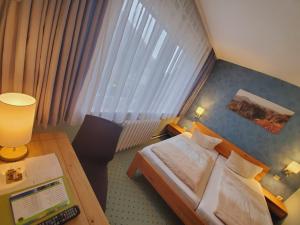 a hotel room with a bed and a desk with a laptop at Pension Am Nationalpark in Stadt Wehlen