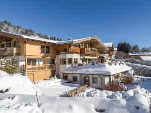 ein Haus im Schnee mit schneebedecktem Hof in der Unterkunft TraumChalet mit Sauna in Kirchberg im Skigebiet Kitzbühel in Kirchberg in Tirol