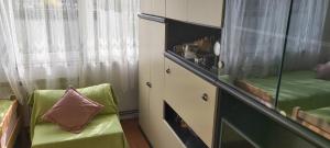 a bedroom with a green chair and a dresser at Apartman Ljubica in Daruvar