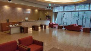 a lobby with red chairs and a waiting room at Tourist Inn Kochi in Kochi