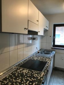 a kitchen with white cabinets and a sink at Haus Friedel 2 in Überlingen