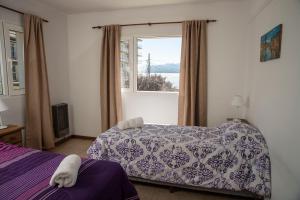 een slaapkamer met 2 bedden en een raam bij DEPARTAMENTO CÉNTRICO CON VISTA AL LAGO in Bariloche