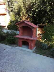 una casa de perros de ladrillo rojo sentada en un patio en Apartments Maćo, en Petrčane