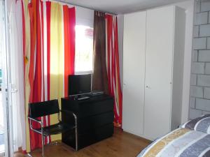 una camera con letto e scrivania con TV di Studios Faoug a Faoug