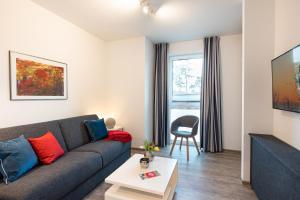 a living room with a couch and a table at Appartement "Haffglück" mit Penthouseflair - Oase am Haff in Garz