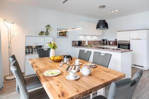 GarzにあるAppartement "Haffglück" mit Penthouseflair - Oase am Haffの木製のテーブルと椅子のあるキッチンとダイニングルーム