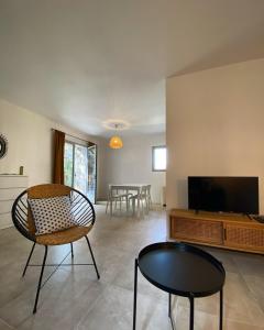 a living room with a television and a table and chairs at Résidence Casarella Lama in Lama