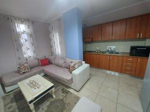 uma sala de estar com um sofá e uma cozinha em Bral Apartment 3 em Durrës
