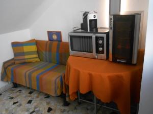 a couch with a microwave and a tv on a table at Le Rose Malpensa in Busto Arsizio